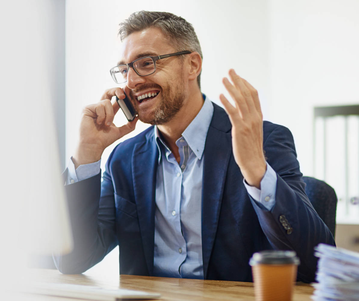 aged man with big happy smile talking on cell phone with one hand gesturing