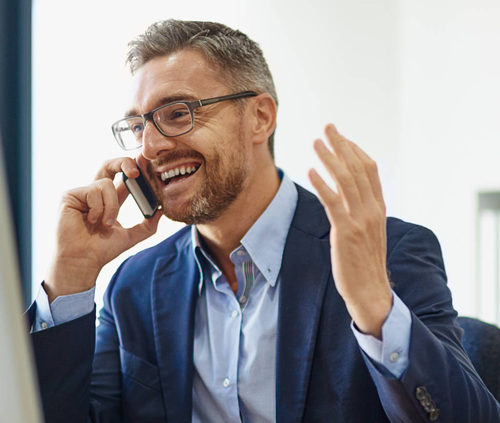 aged man with big happy smile talking on cell phone with one hand gesturing